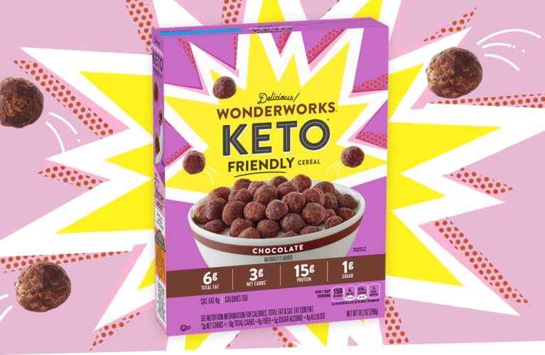 A purple box of delicious Wonderworks Chocolate Keto friendly cereal. Cereal pieces explode from the box.