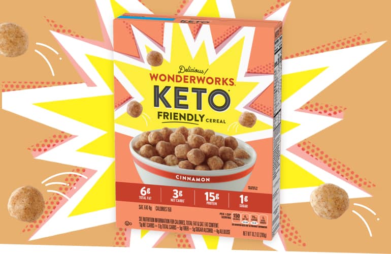 An orange box of delicious Wonderworks Cinnamon Keto friendly cereal. Cereal pieces explode from the box.
